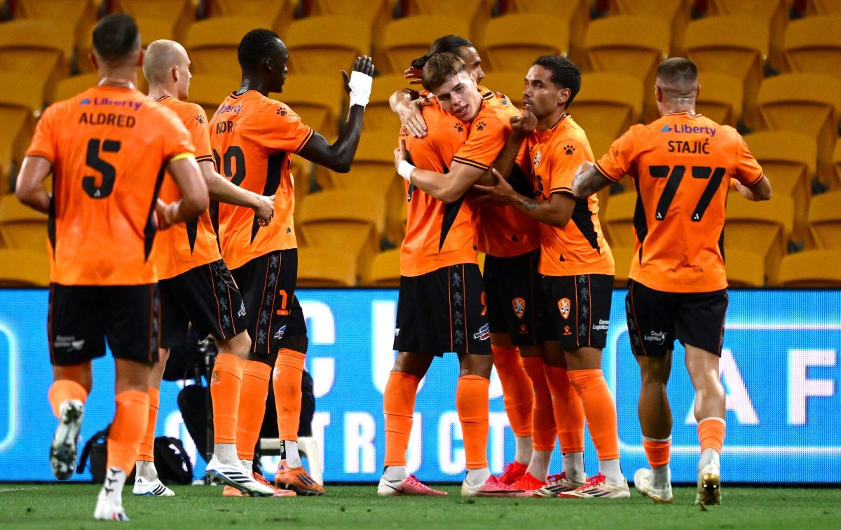Justin Vidic of the Roar celebrates with team mates after scoring a goal at Suncorp Stadium.