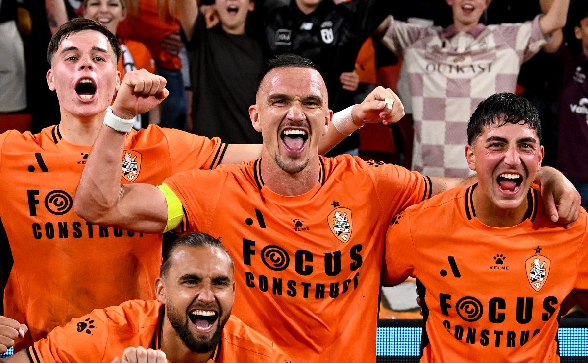 Tom Aldred of the Roar celebrates victory with his team mates after the match at Suncorp Stadium.