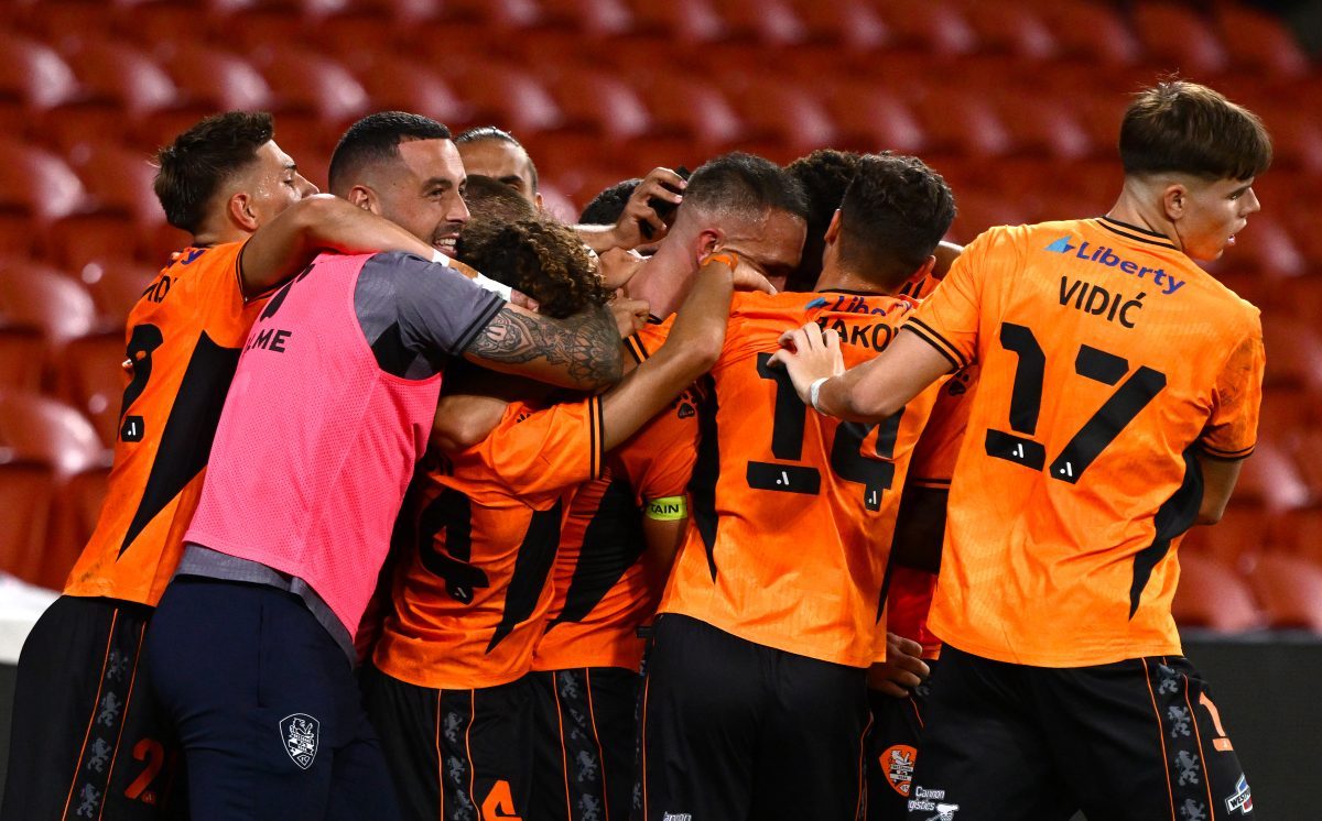 Tom Aldred of the Roar celebrates with team mates after scoring a goal at Suncorp Stadium.